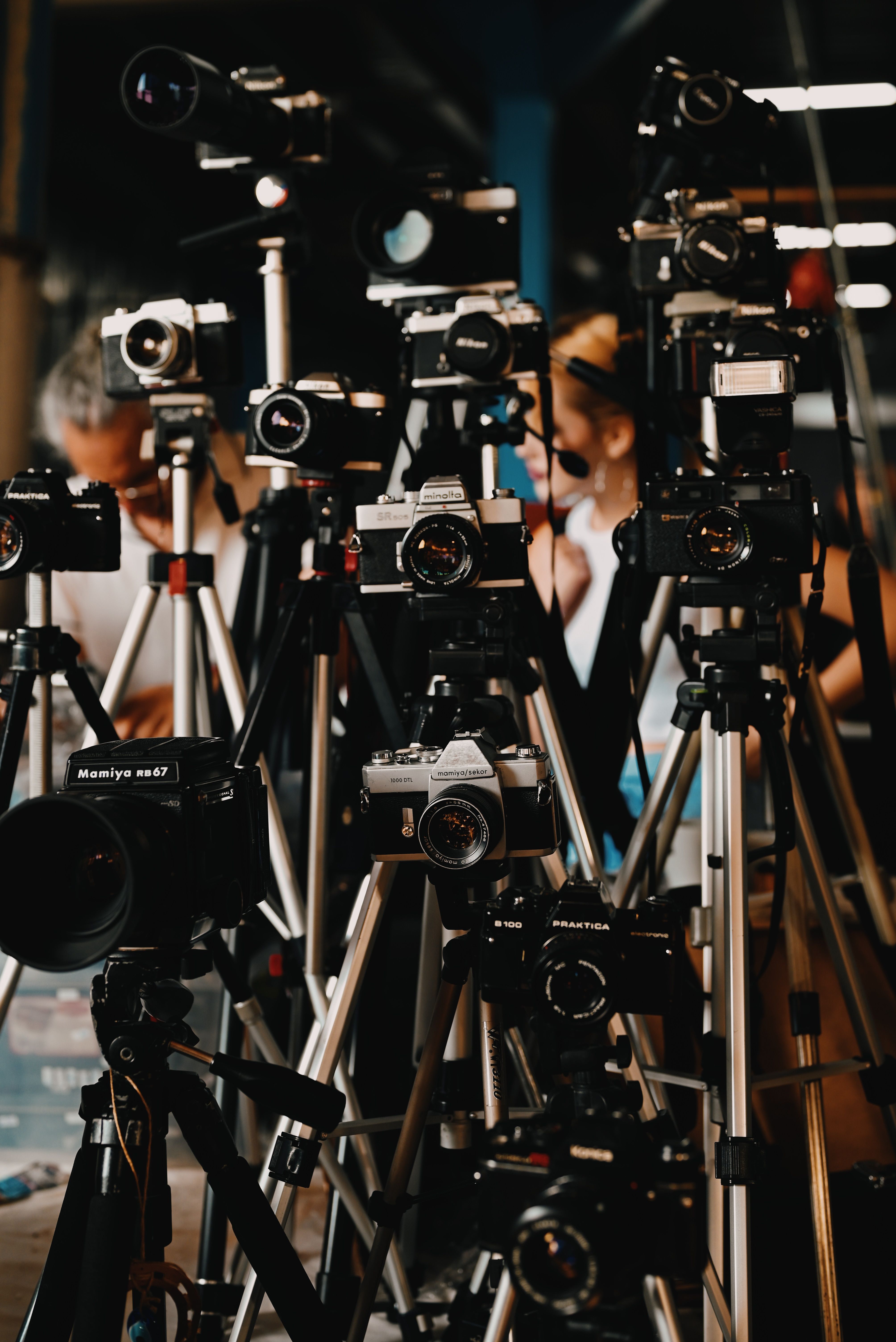 Vintage cameras on tripods in a photography studio setting, capturing a classic and artistic atmosphere.