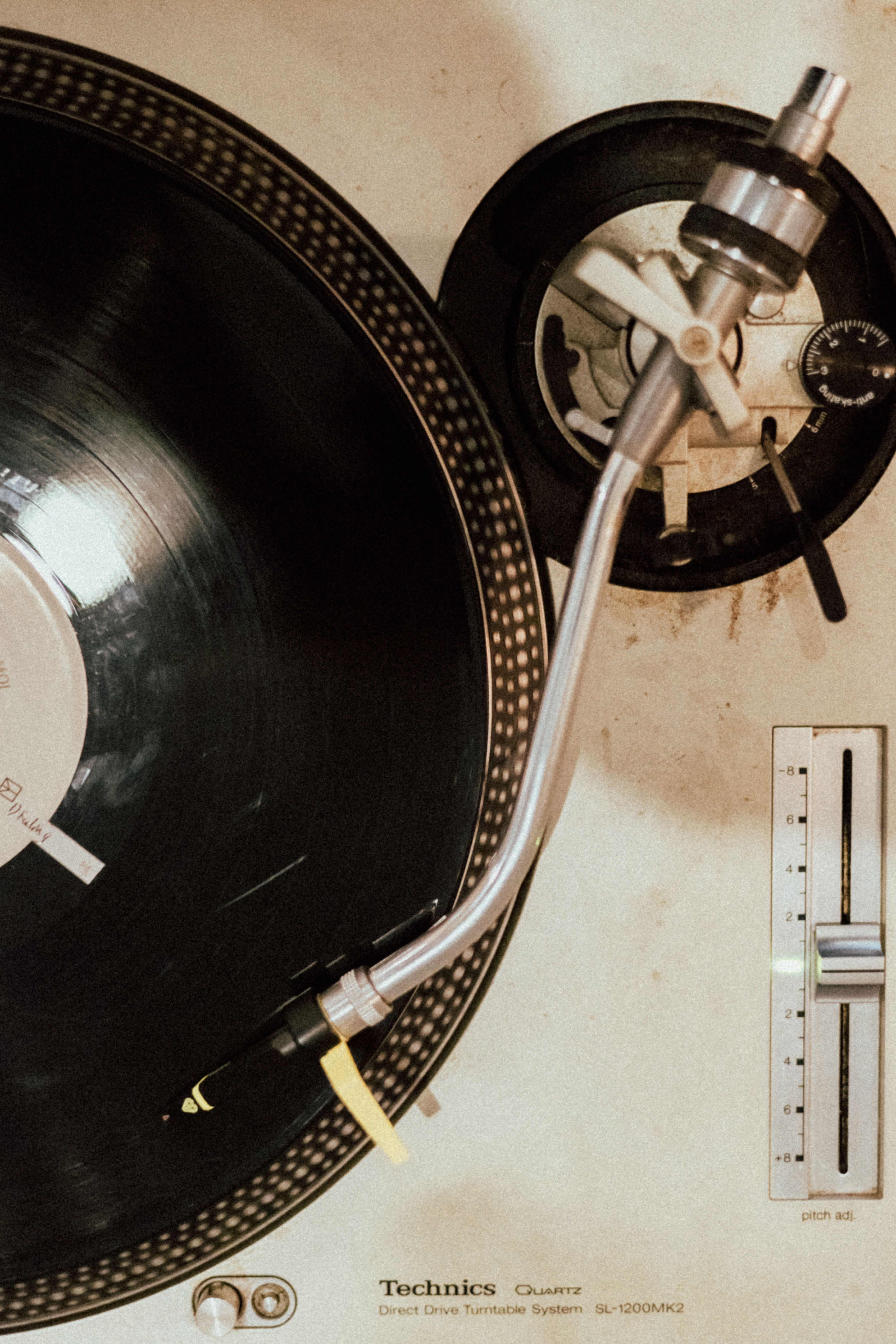 Close-up top view of a vintage Technics turntable playing a vinyl record, capturing nostalgic vibes.