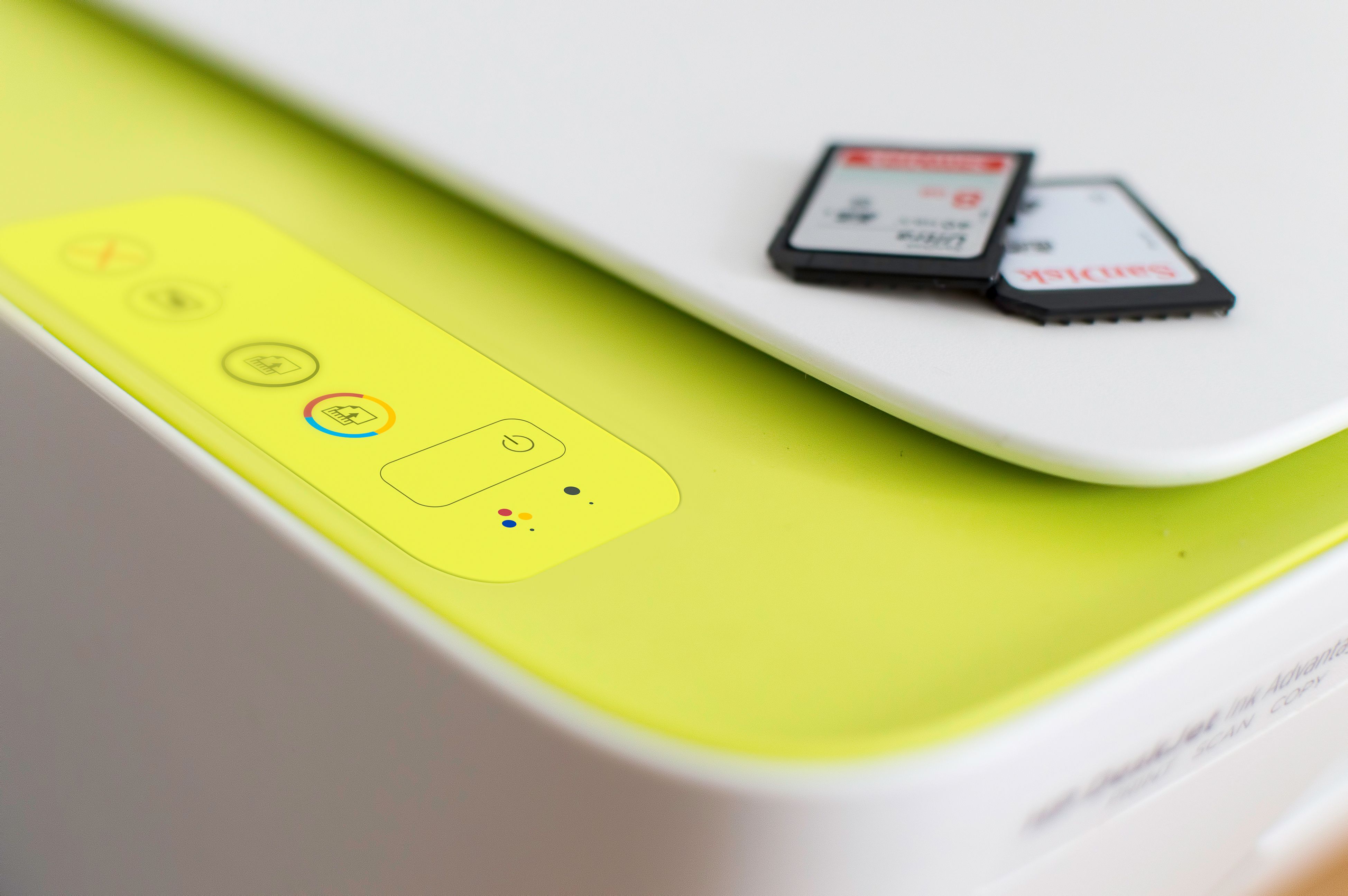Detailed shot of a printer's control panel with SD cards on top, highlighting modern tech.