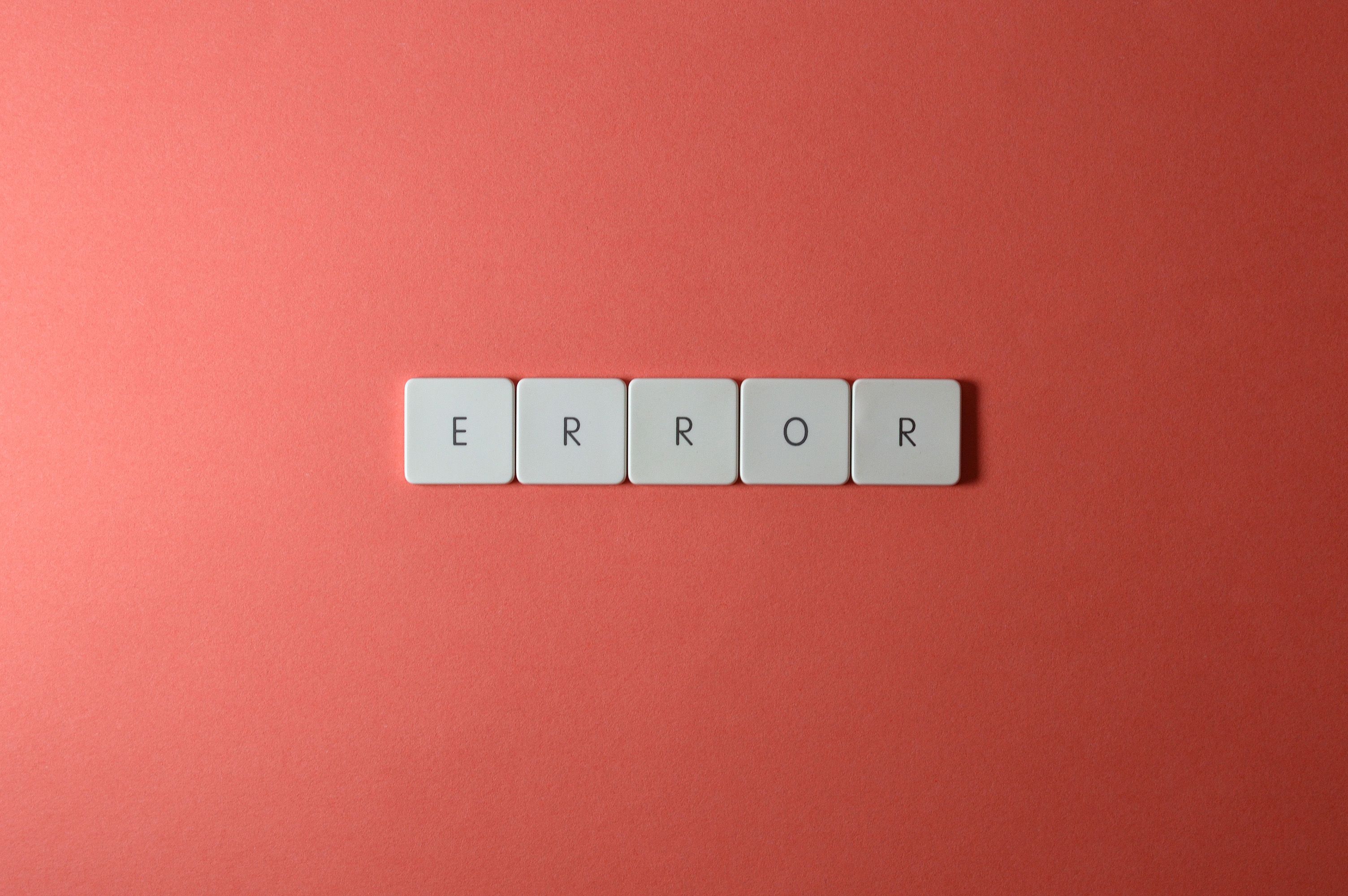 White letter tiles spelling 'ERROR' on a red backdrop, offering a minimalist design concept.
