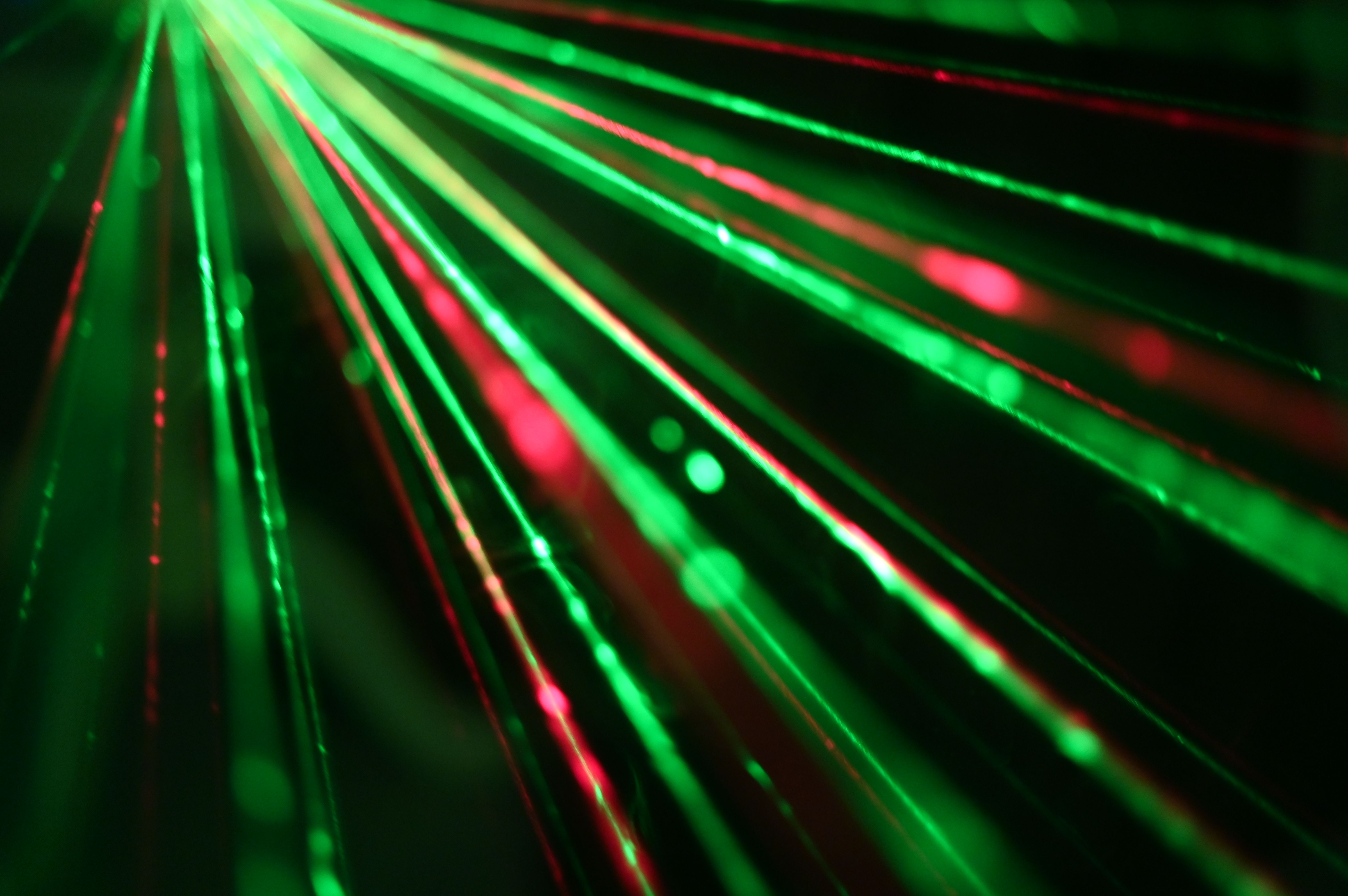 Dynamic display of red and green laser beams creating an abstract and vibrant visual effect.
