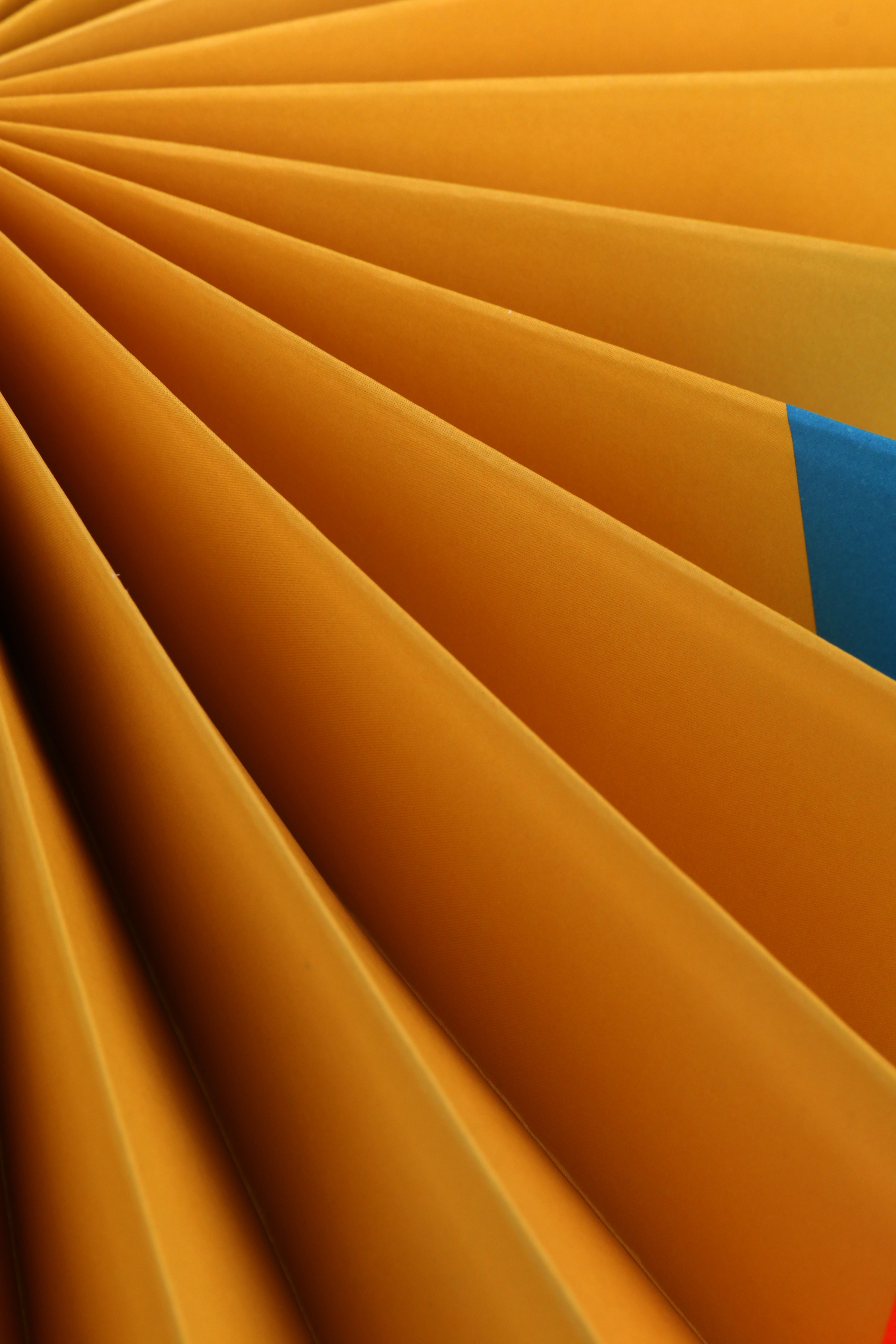 Abstract close-up of orange file folders with a standout blue tab, emphasizing organization and office supplies.
