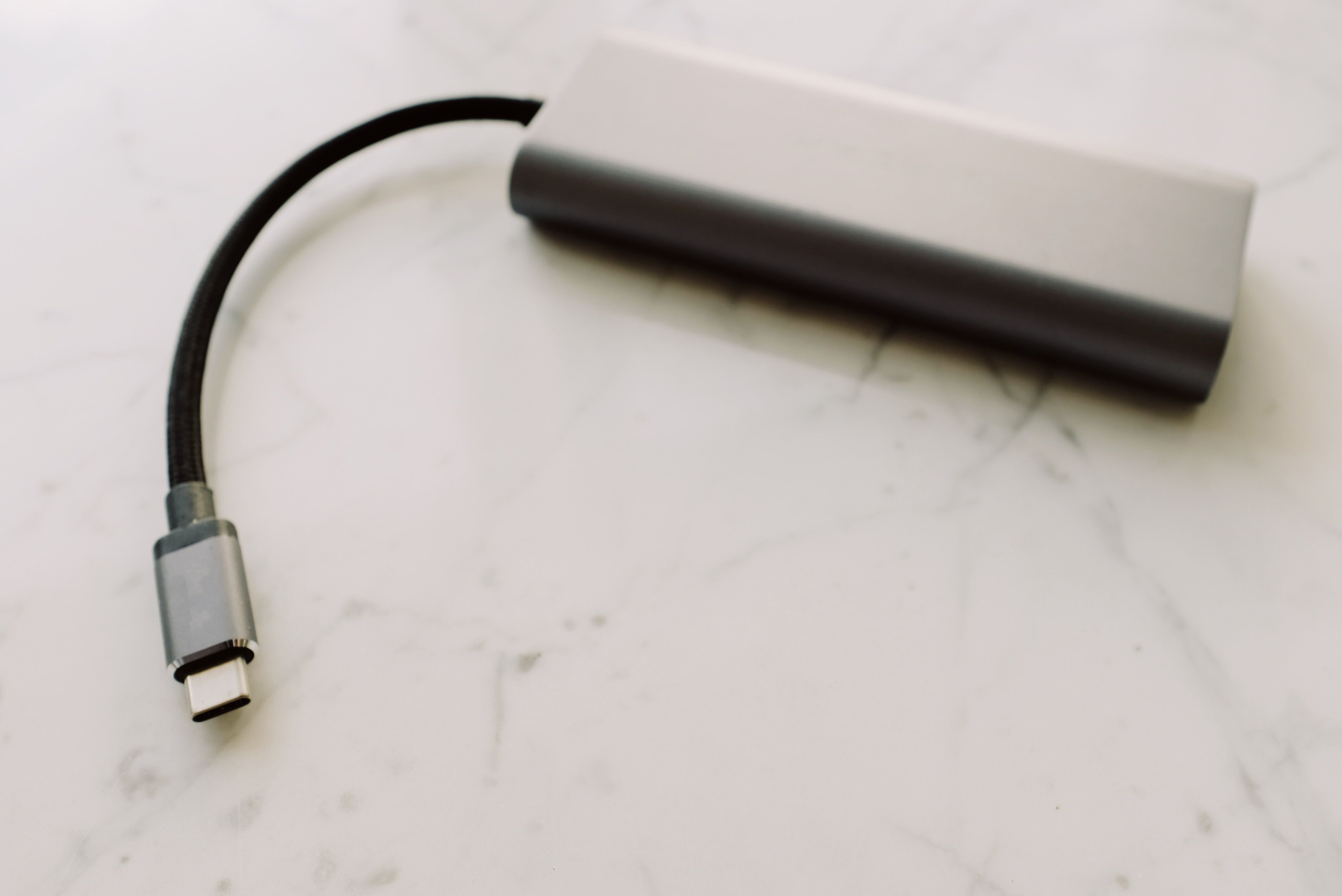 Close-up of a USB-C adapter on a marble surface, showcasing modern technology.