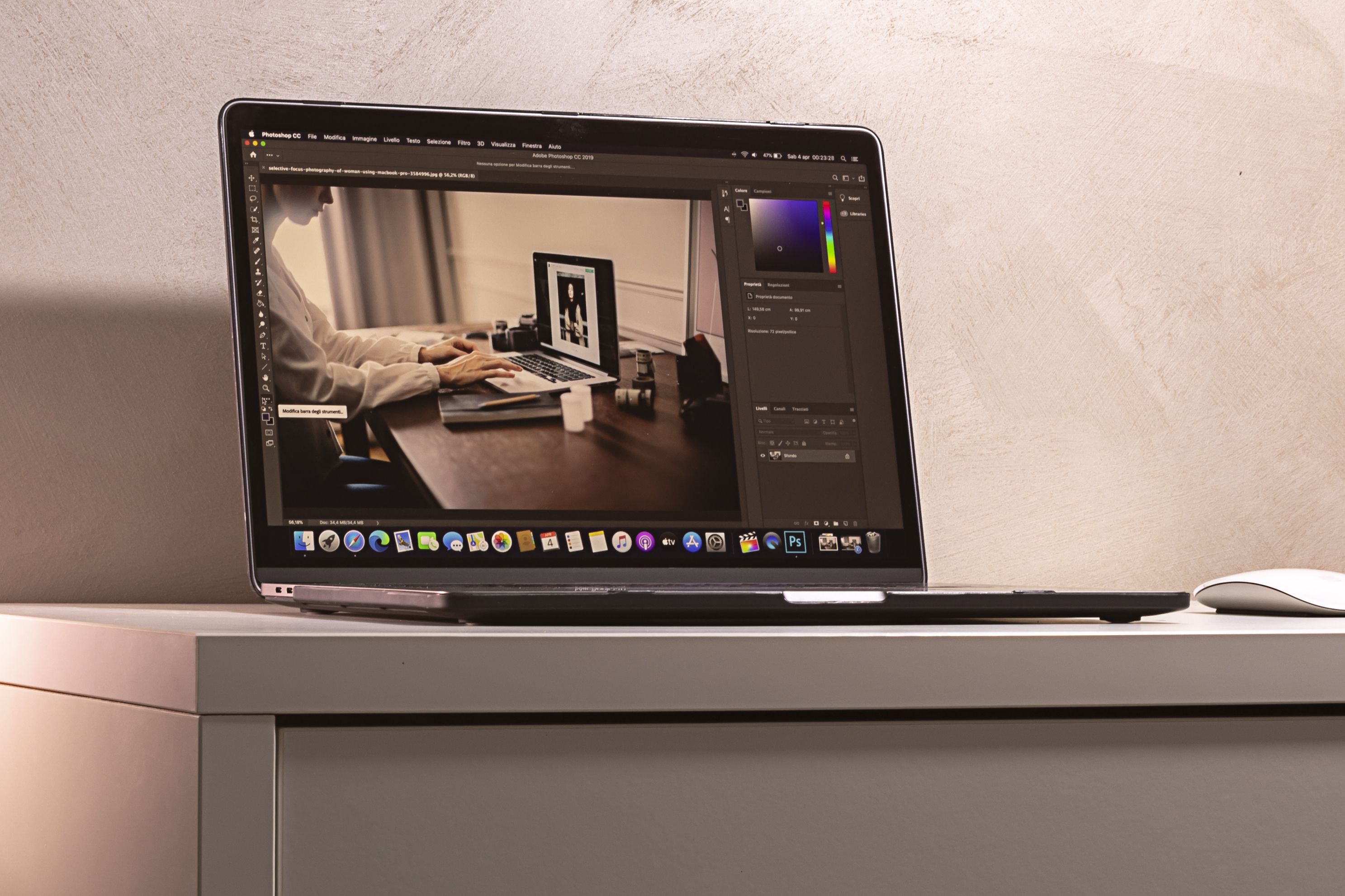 A laptop displaying a photo editing software interface on a clean, modern desk setup.