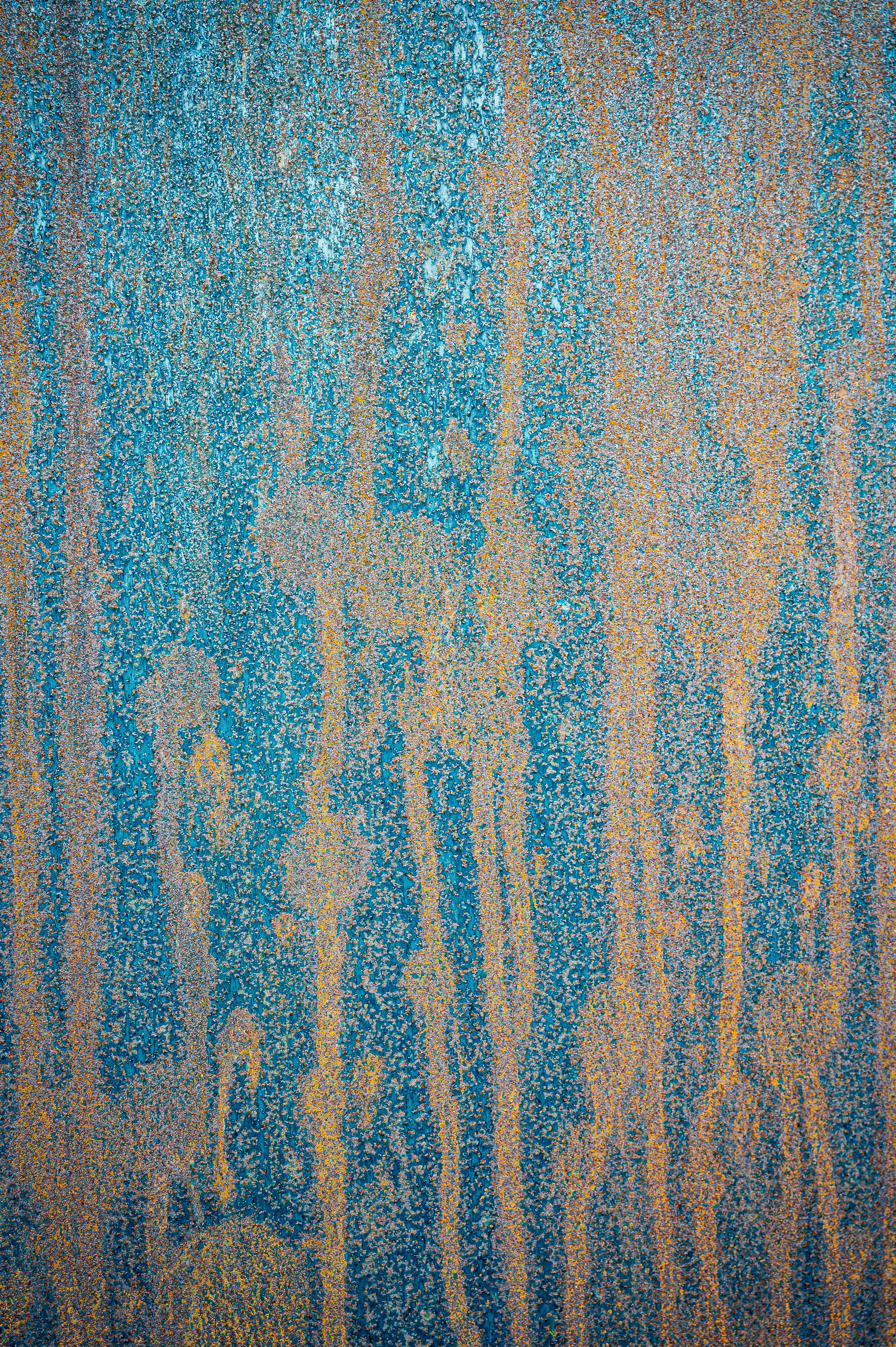 Abstract wallpaper of weathered grunge light blue wall with stains and stripes of beige color