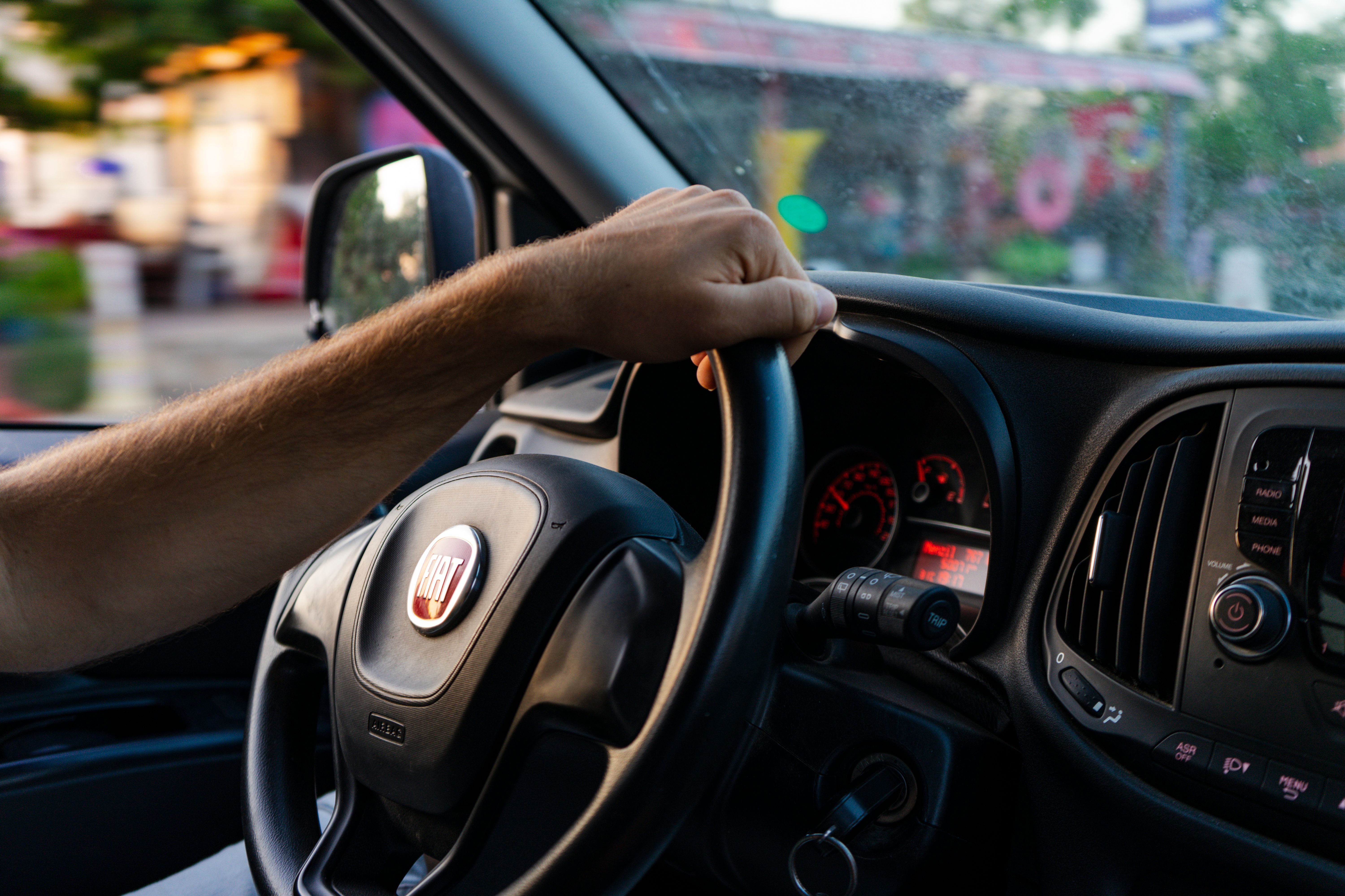 Close-up of a hand on a Fiat steering wheel while driving in Fethiye, Türkiye.
