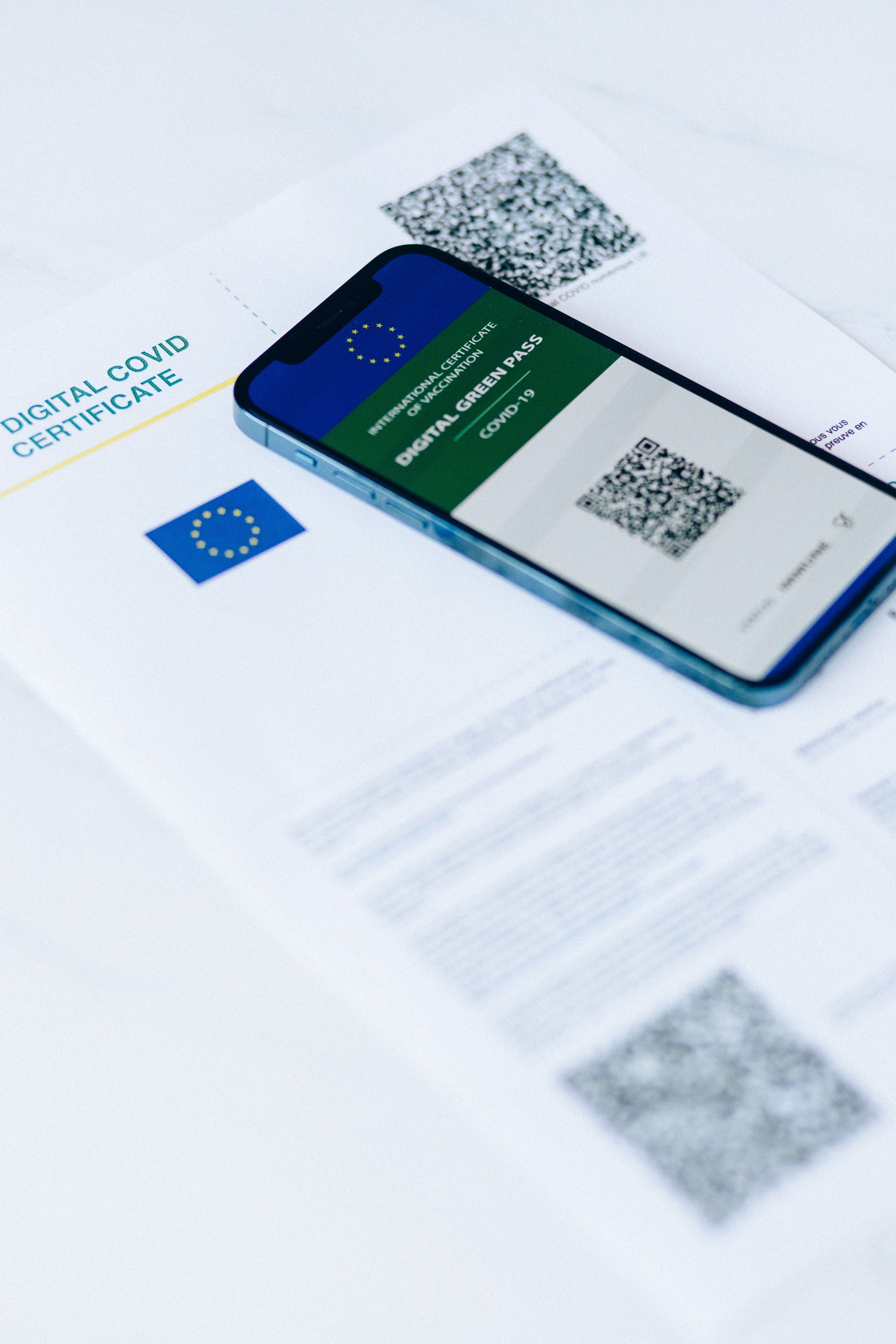 Smartphone showing digital COVID pass on document with QR codes.